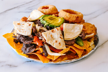 Stacked nachos with beef onion rings and tortillas