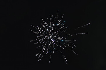 Fototapeta premium Large sparks from the explosion of fireworks against the black sky at night. Texture, photography.