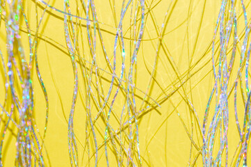 silver holographic tinsel fringe on an illuminating yellow background