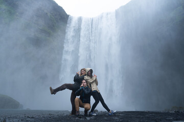 photo of happy tourist friends at the Skógafoss waterfall in Iceland