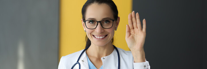 Smiling female doctor graciously holds her hand. Medical center services concept