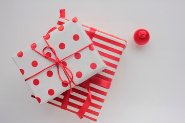 Gift box wrapped in red and white wrapping paper and tied with ribbon and on white background....