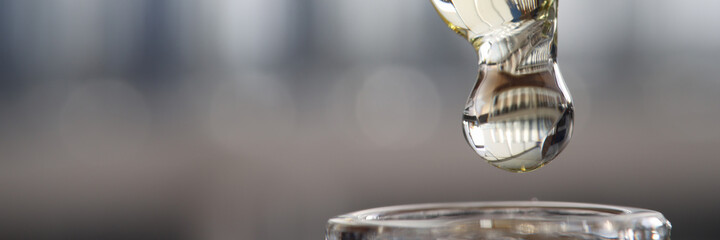 Drop of clear liquid drips into test tube. Research in medicine and public health concept © H_Ko