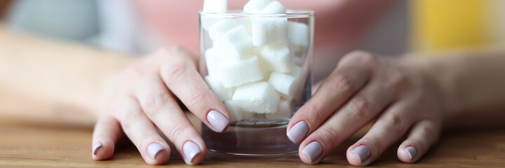 Female hands hold glass with sugar. Sugar addiction how to get rid of concept