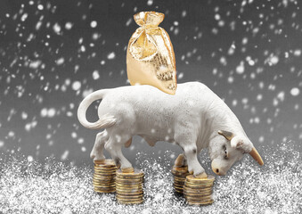 Miniature model of a bull with money coins and a bag of gifts. Bull as a symbol of 2021 reliability...