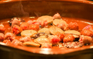 Traditional Spanish sausages frying in a clay pot