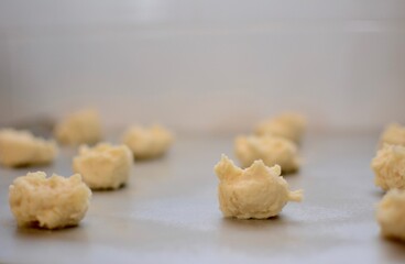 Christmas cookie dough ready for the oven on a greased tray close-up with bokeh.