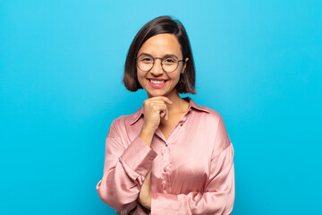 young hispanic woman smiling, enjoying life, feeling happy, friendly, satisfied and carefree with...