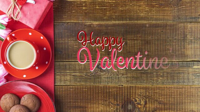 Morning cup of coffee, chocolate cake, gift or present box, candles and flower on rustic wooden table from above. Stop motion video with Happy Valentines Day text.