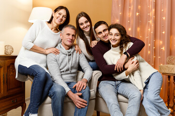 a group of people of different ages. father, son, mother, sister, wife, daughter, husband. New Year's holidays, Christmas mood. the room is decorated with New Year's decorations. happy family.