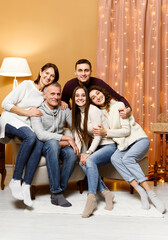 mom and dad are sitting in a chair. husband with wife and sister next to their parents. children and parents. new year holidays. Christmas. weekend with family