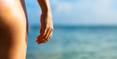 Woman standing on the beach in front of the ocean. Outdoor leisure.