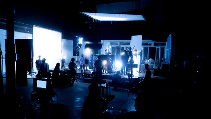 Silhouette images of video production behind the scenes or b-roll or making of TV commercial movies that film crew team lightman and videos cameraman working together with movie director in studio. - obrazy, fototapety, plakaty