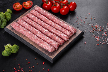 Fresh raw pork sausages with spices on a wooden cutting board
