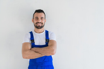 A foreman stands with folded arms on his chest and smiling