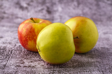 Green and red apples on blackboard or chalkboard background. Close-up on a gray background.Ideal food for diet.