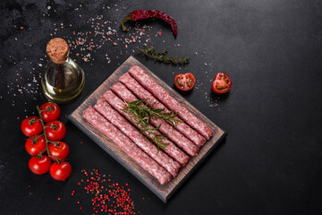 Fresh raw pork sausages with spices on a wooden cutting board