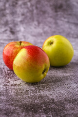 Green and red apples on blackboard or chalkboard background. Close-up on a gray background.Ideal food for diet.