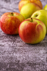 Green and red apples on blackboard or chalkboard background. Close-up on a gray background.Ideal food for diet.