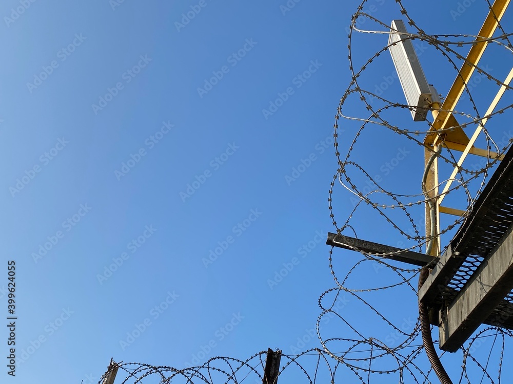 Wall mural the barbed wire against the blue sky.