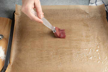 Greasing a baking sheet covered with baking paper