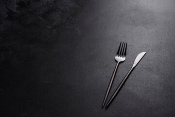 Black cutlery on a concrete dark table. Dining table