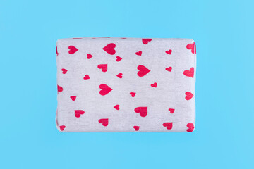 Gift box wrapped in paper with hearts on blue background. Minimal Valentines day concept.