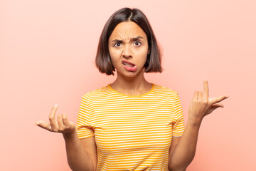 young hispanic woman feeling clueless and confused, not sure which choice or option to pick,...