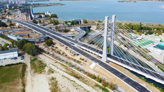 Ciurel passage, bridge over a river with moving cars, recreational complex, lake. View from the drone. Bucharest, Romania