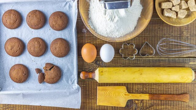 Chocolate cookies theme flat lay creative layout overhead with baked ingredients and tools utensils on rustic wooden table top. Stop motion animation