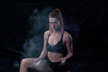 girl athlete clapped her hands forming a small cloud of talcum powder