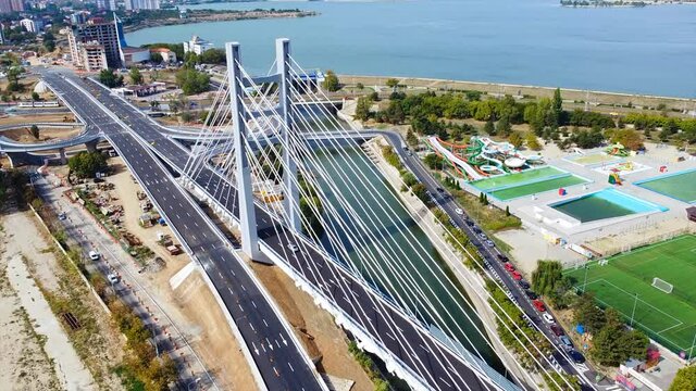 Ciurel passage, bridge over a river with moving cars, recreational complex, lake. View from the drone. Bucharest, Romania