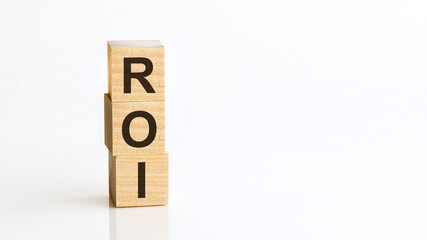 ROI - acronym from wooden blocks with letters, Return on Investment. White background.