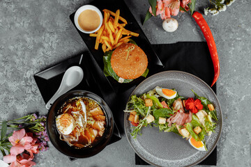 three-course business lunch. Lunch with burger asian ramen noodles and caesar salad