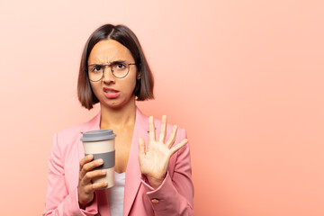 young hispanic woman feeling disgusted and nauseous, backing away from something nasty, smelly or...