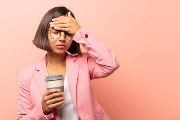 young hispanic woman covering face with both hands saying no to the camera! refusing pictures or...