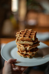 A big stack of Belgian sourdough waffles in a white plate