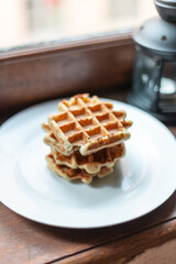 A big stack of Belgian sourdough waffles in a white plate