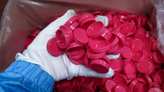 red plastic bottle cap.photo of plastic injection parts on site of plastic factory, in plastics industry.