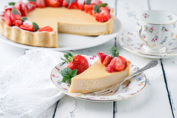 Traditional German cheesecake with strawberry fruits served as close-up on a classic design plate with tablecloth