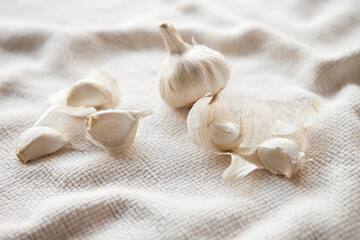 Garlic on white tablecloth, natural light photo. Eating garlic boosts the immune system, health, protects from cold flu, and corona virus.
