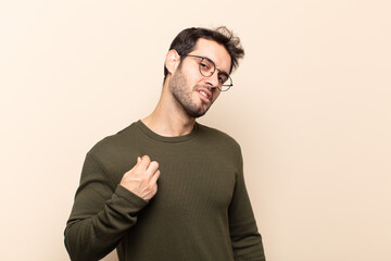 young handsome man looking arrogant, successful, positive and proud, pointing to self