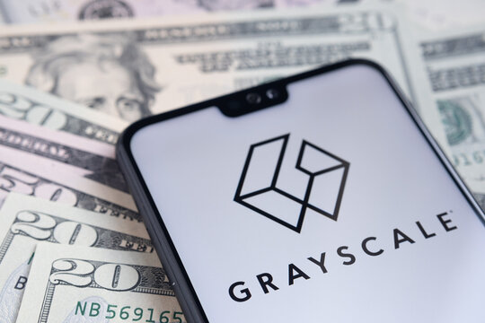 Stafford / United Kingdom - November 15 2020: Grayscale Bitcoin Trust Company Logo Seen On The Screen Of Smartphone, Placed On Dollar Bills.