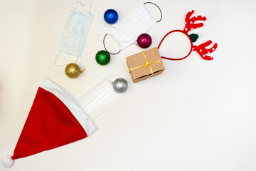 Santa Claus hat with gifts, antler and christmas balls and medical mask. Christmas flat lay