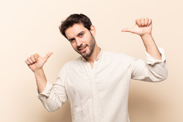 young handsome man feeling proud, arrogant and confident, looking satisfied and successful,...