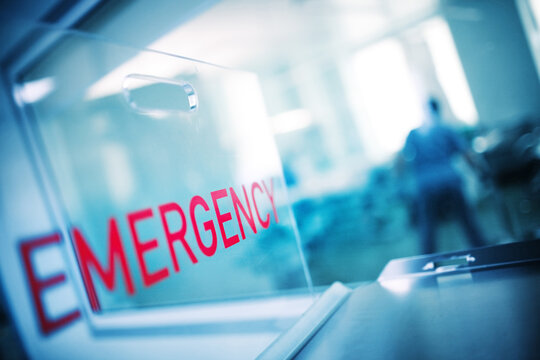 The inscription "urgency" on the plastic glass against the background of the hospital emergency room