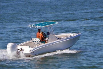 Fototapeta premium Young couple cruising in an open white fishing boat.