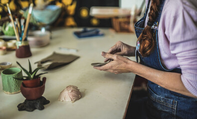 Fototapeta na wymiar Woman work in creative ceramic pottery studio with clay - Concept of handmade handcraft
