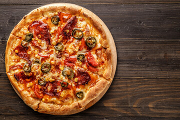 Fresh pizza with tomato sauce, black olives, mozzarella cheese, ham on wooden table closeup. Space for text or copy space. Pizza menu. Restaurant menu advertise
