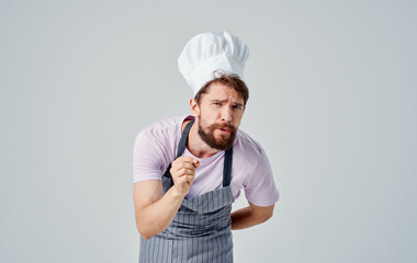 professional chef man in a headdress on a light background cropped view